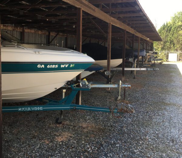 A row of boats parked in the gravel.